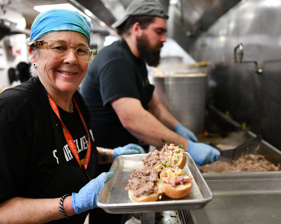 Woman serving lunch in kitchen during Chef for Feds effort